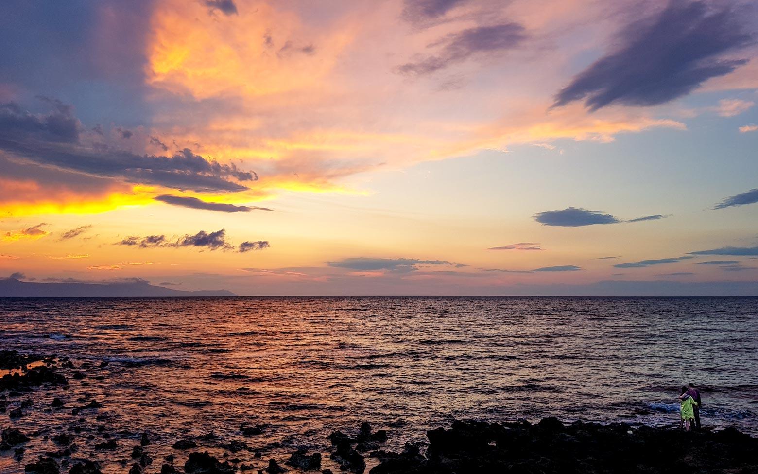 couple watching beautiful sunset on the shores