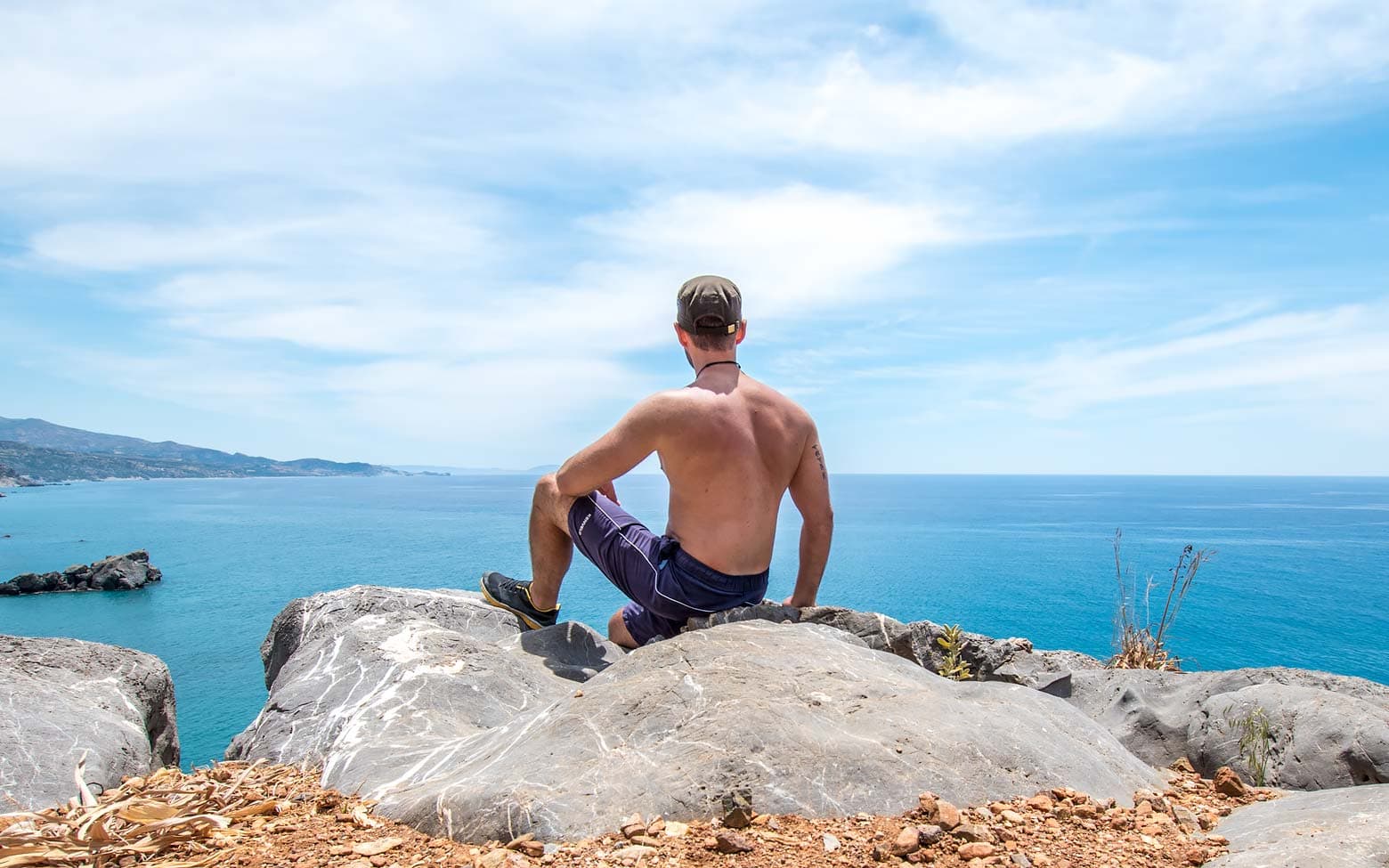 man sitting on a rock in greece