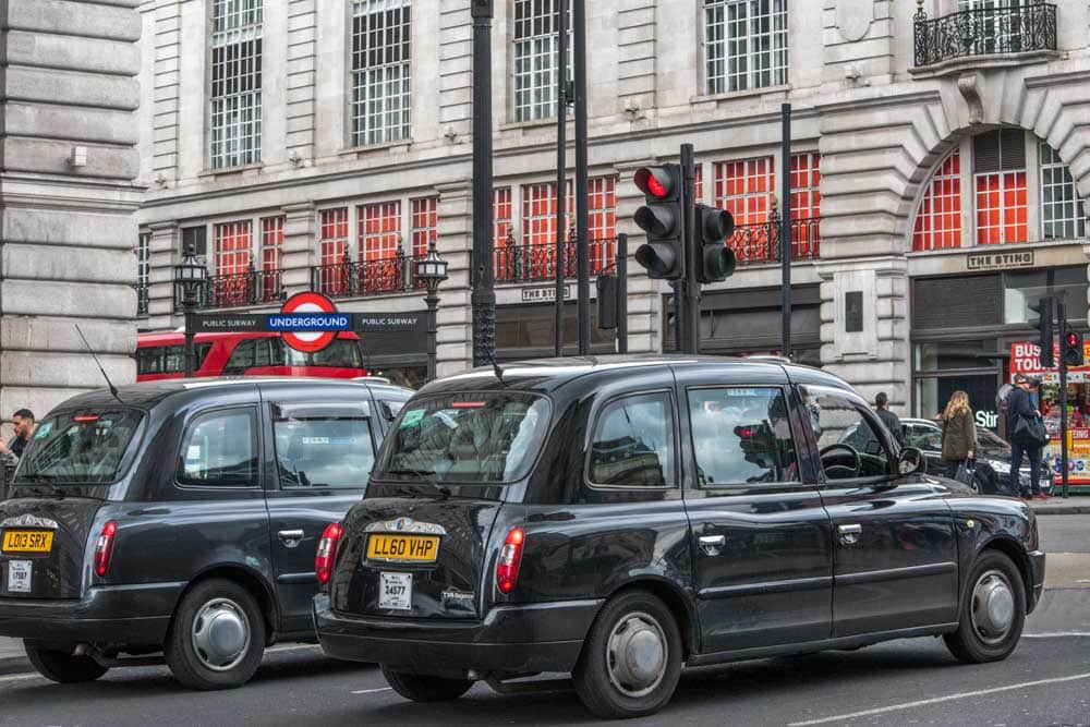 zwei schwarze Taxis warten an einer Ampel in London