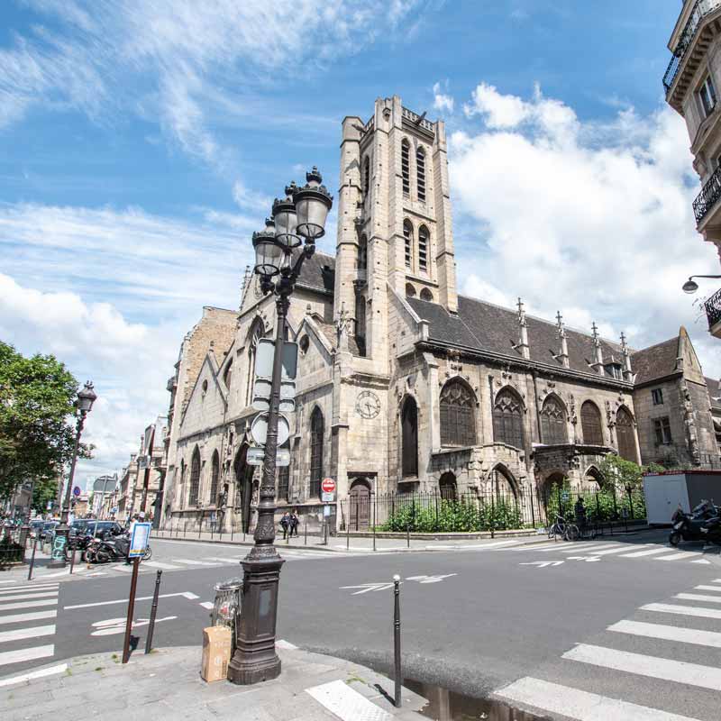 Streets in Paris with an old church in the background