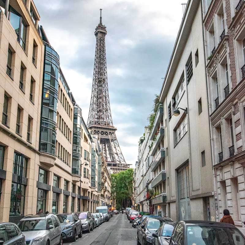 Eiffel Tower rising behind buildings