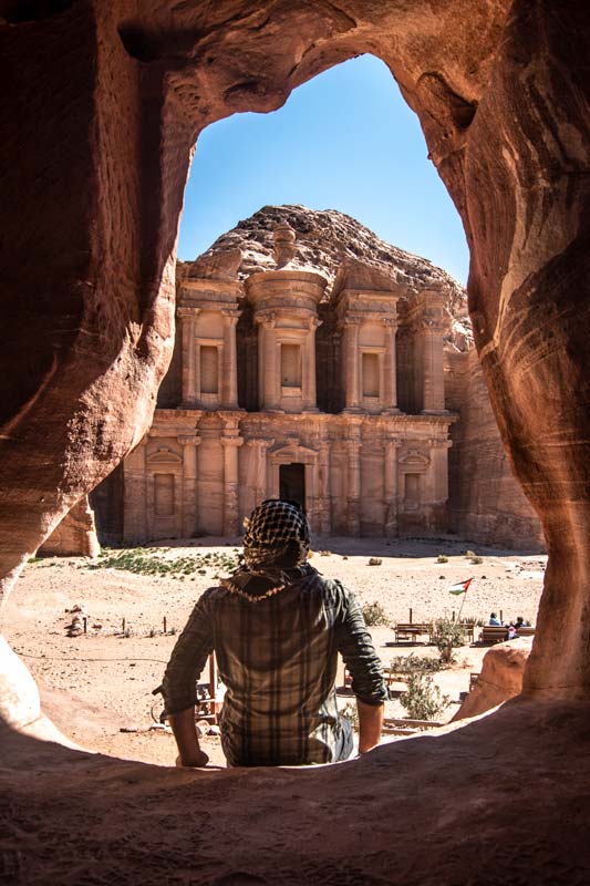 man sitting in a cave in front of the monastery