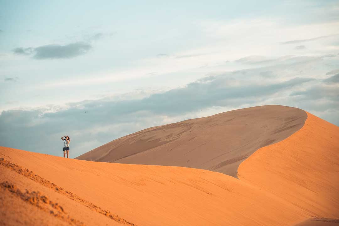 girl-taking-photos-on-a-sand-dune