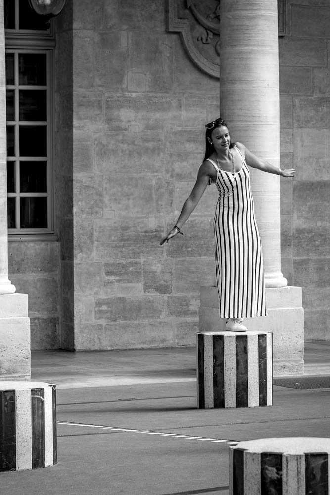 girl-posing-for-a-photo-on-a-column-black-and-white