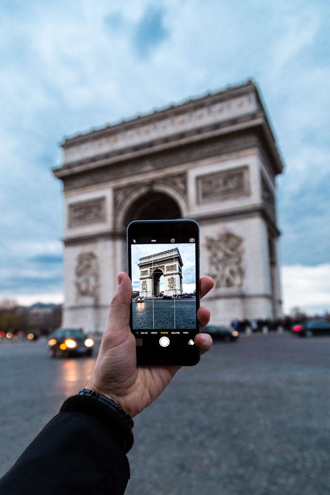 man-taking-a-phone-photo-of-arc-de-triomphe