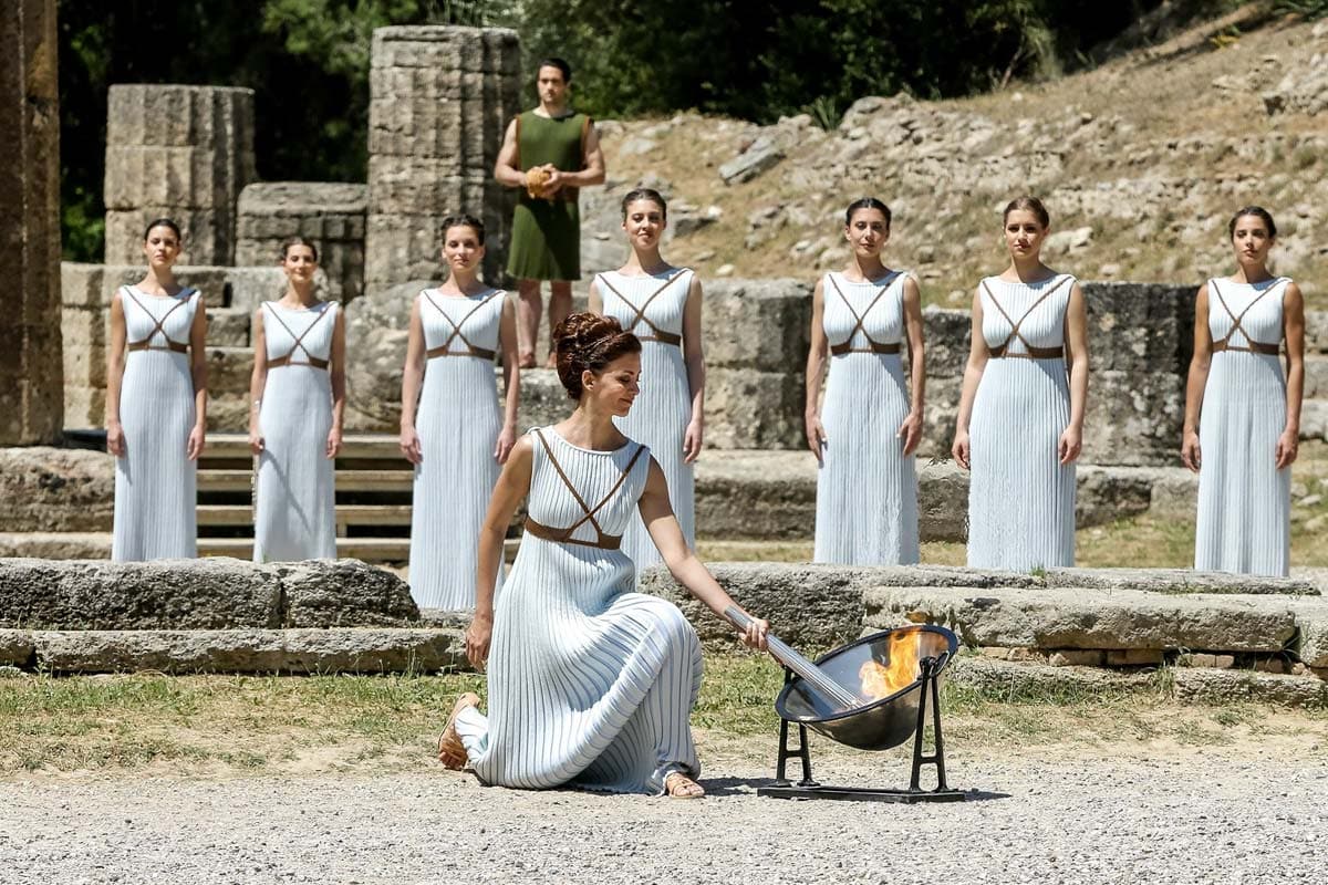 girl-in-traditional-greek-attire-lightning-up-an-olympic-torch