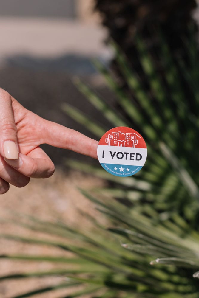 -a-finger-with-I-voted-sticker