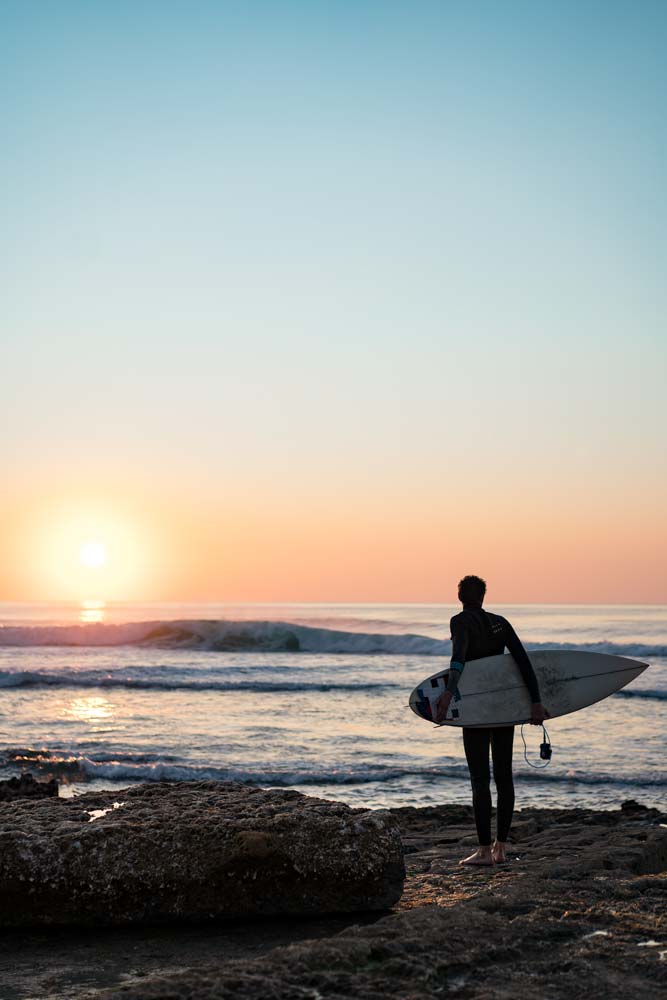 fun-portugal-facts-man-with-a-surf-board-standing-on-the-beach