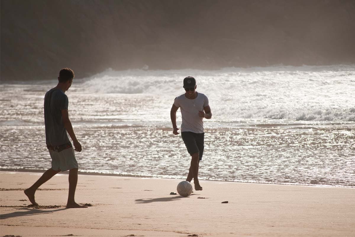 two-men-playing-football-on-the-beach