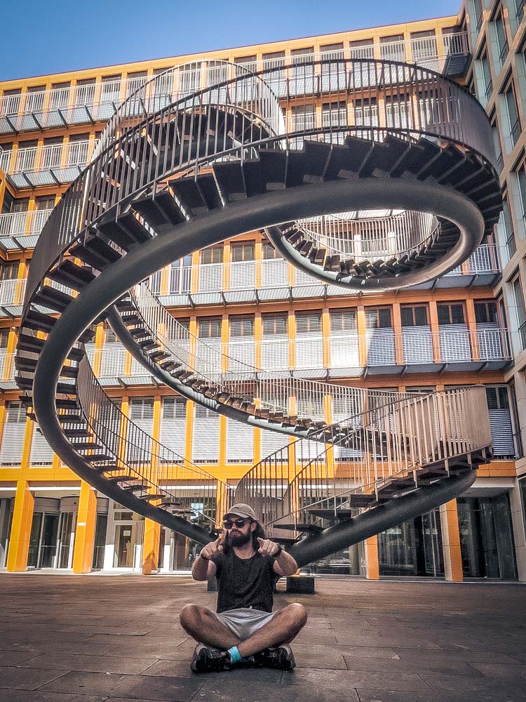 man-sitting-infront-of-a-staricase-art